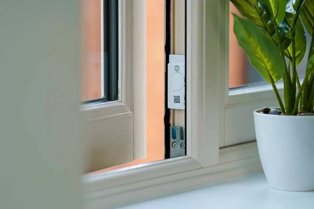 Yale window sensor fitted to a white window frame