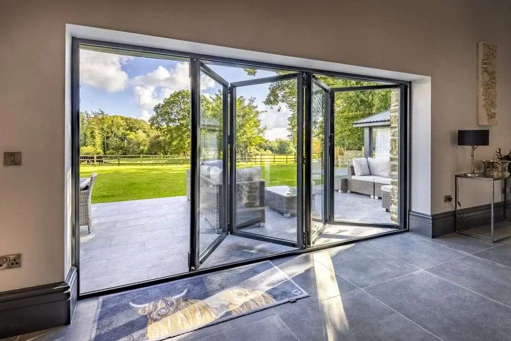 Open bi-fold doors leading from a living room to a garden patio