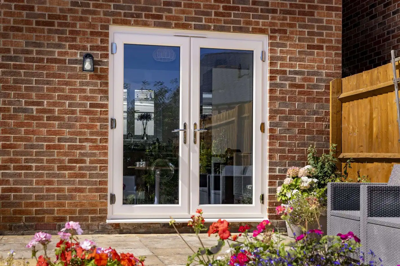 White French doors fitted to a red brick home