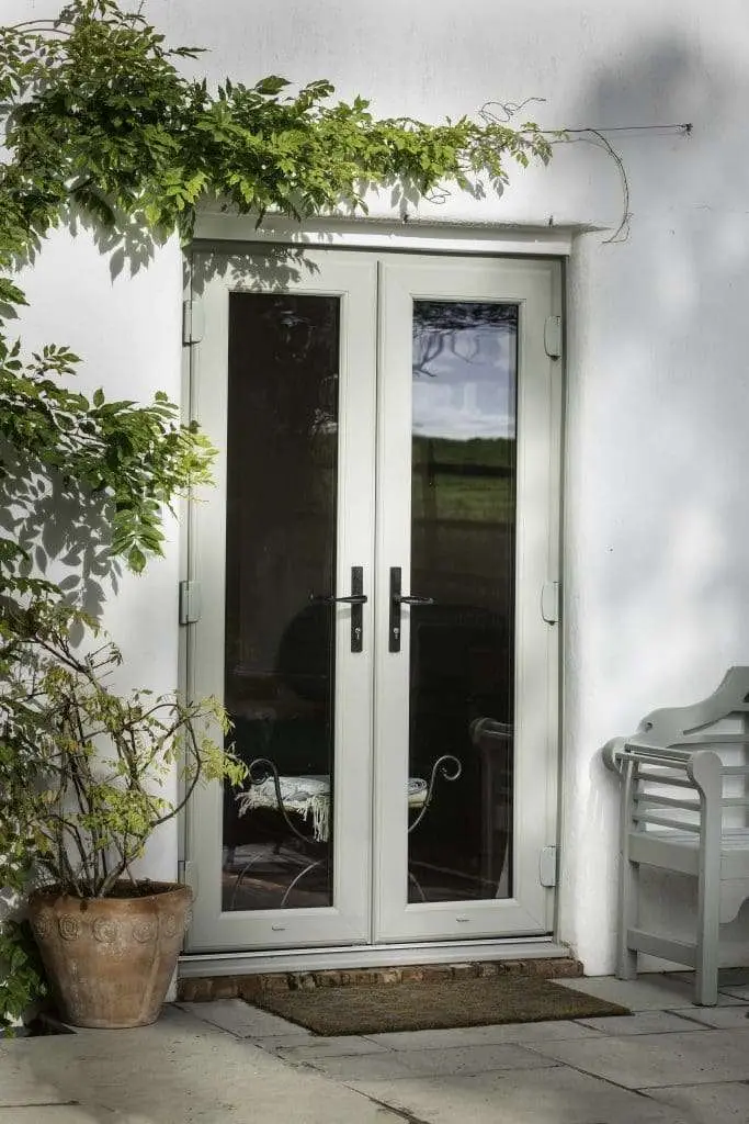 White uPVC French doors with side panels on a rendered house