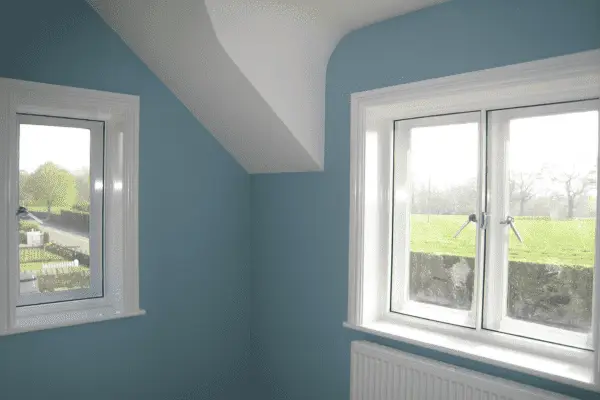 Secondary glazing fitted inside white windows in a blue-painted room